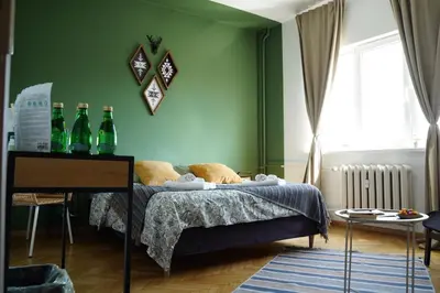 a bedroom with green walls and a bed with bottles on it at NDK Skyline Studio in Sofia