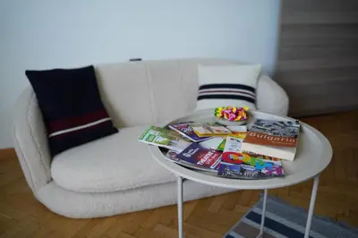 a white coffee table with books and a chair at NDK Skyline Studio in Sofia