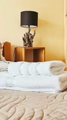a bedroom with a bed with white sheets and a lamp at Forest nest Cozy apartment white balcony on the hill in Bansko