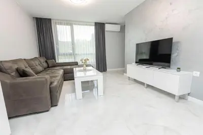 a living room with a couch and a flat screen tv at White lux in Sandanski