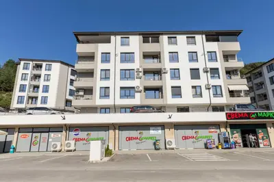 a large white building with a parking lot in front of it at White lux in Sandanski
