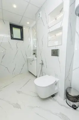 a white bathroom with a toilet and a sink at White lux in Sandanski