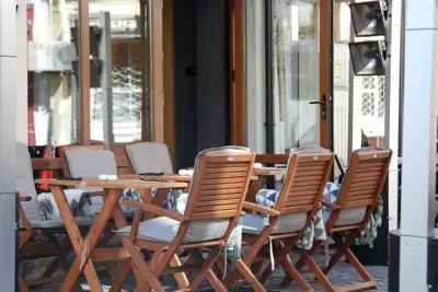 a wooden table and chairs on a patio at 1BR Apartment with a Free Designated Parking Space in Plovdiv