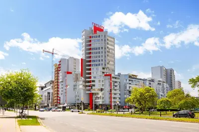 a tall white building with a red sign on it at 1BR Apartment with a Free Designated Parking Space in Plovdiv