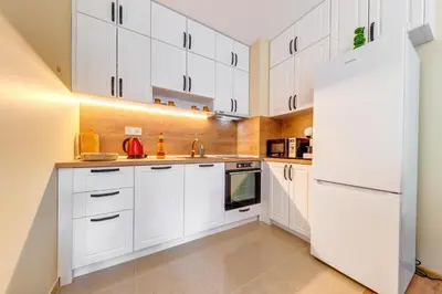 a kitchen with white cabinets and a white refrigerator at Forest Harmony 1BD with Balcony & Parking by Flat Manаger in Smolyan