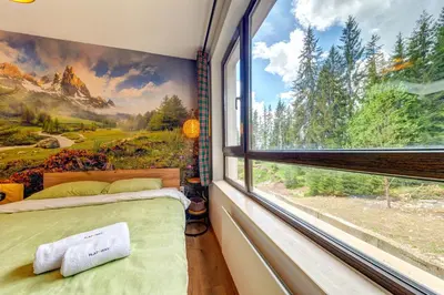 a bedroom with a window with a view of the mountains at Into the Woods - Charming Studio by Flat Manager in Smolyan