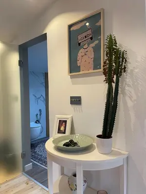 a room with a table with a plant and a picture at Boutique apartment with Mountain View in Sofia