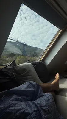 a person laying in bed in front of a window at Boutique apartment with Mountain View in Sofia