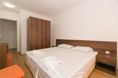 a bedroom with a large white bed and a wooden cabinet at Вилно селище Тракия- почивка сред природата in Tsigov Chark