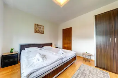 a bedroom with a large bed with white sheets at Pamporovo Palace - 2BD next to the Ski Slopes by Flat Manager in Pamporovo