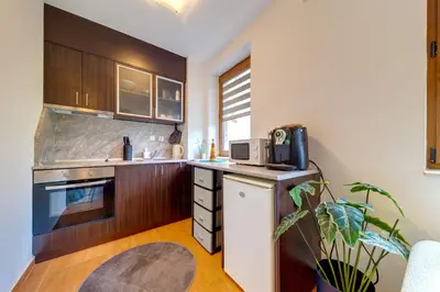 a kitchen with wooden cabinets and a microwave at Pamporovo Palace - 2BD next to the Ski Slopes by Flat Manager in Pamporovo