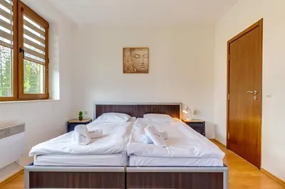 a bedroom with a large bed with white sheets at Pamporovo Palace - 2BD next to the Ski Slopes by Flat Manager in Pamporovo