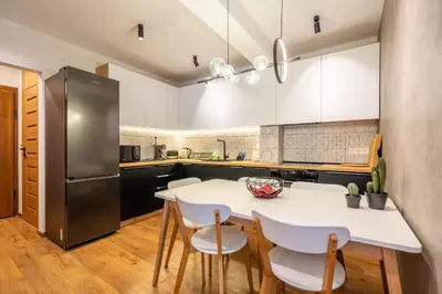 a kitchen with a white table and chairs at Arte Apartment in Sofia