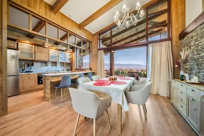 a kitchen and dining room with a table and chairs at Luxury Mountain Villa Pirin Golf K29H02 by Top Kvartiri Ltd in Razlog