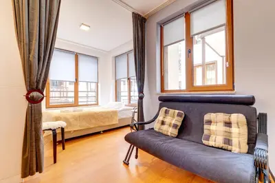 a living room with a couch and a bed and windows at Colorful Retreat - 1BD next to the slopes by Flat Manager in Pamporovo