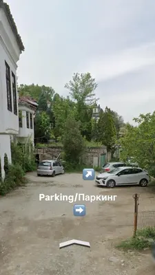 two cars parked in a parking lot next to a house at Комлекс Кристо in Blagoevgrad