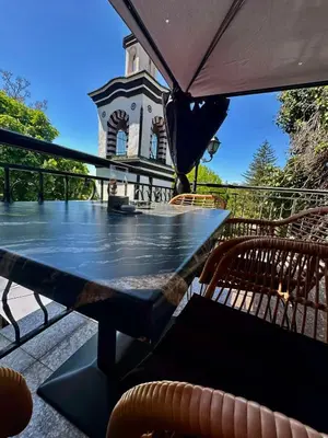 a table with an umbrella on a patio at Комлекс Кристо in Blagoevgrad