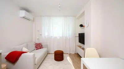 a white living room with a couch and a table at Cozy 1BD Apartment next to NDK by Flat Mаnager in Sofia