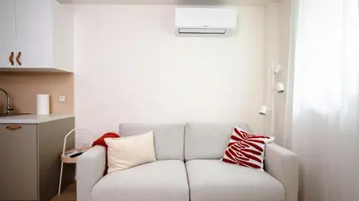 a living room with a couch with pillows on it at Cozy 1BD Apartment next to NDK by Flat Mаnager in Sofia