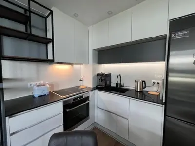 a kitchen with white cabinets and a stainless steel refrigerator at Gran Capital - Vodoley Rose Garden !Free Parking! in Sofia
