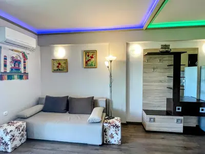 a living room with a white couch and a tv at Апартамент Елегант - спа комплекс Аква Терми in Krasnovo