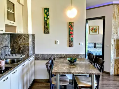 a kitchen with a table and chairs and a sink at Апартамент Елегант - спа комплекс Аква Терми in Krasnovo