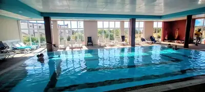 a large swimming pool with people in the water at Апартамент Елегант - спа комплекс Аква Терми in Krasnovo