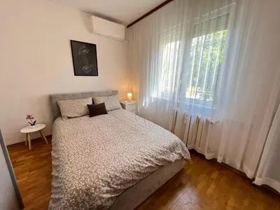 a bedroom with a bed in front of a window at Giza Cozy 1BDR w WiFi near Arena 8888 and SofiaMed in Sofia