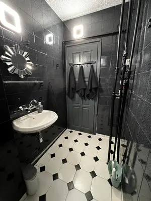 a black and white bathroom with a sink and a shower at Sofia Harmony Apartment in Sofia