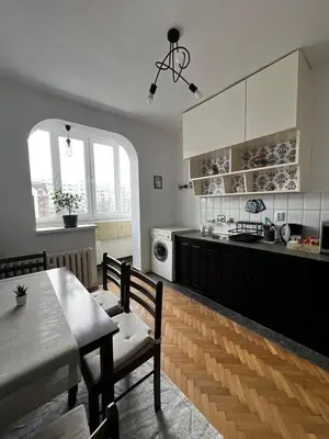 a kitchen with white cabinets and a table and chairs at Sofia Harmony Apartment in Sofia