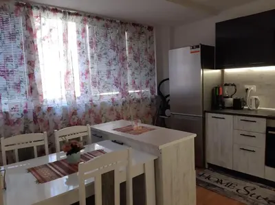 a small kitchen with a table and a refrigerator at Дом Борисови in Sofia