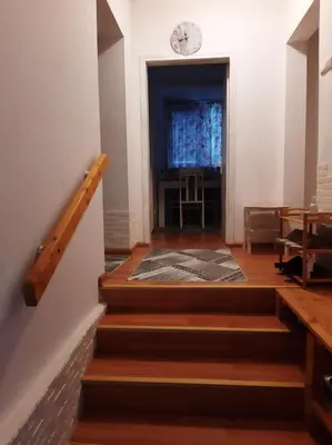 a hallway with stairs and a clock on the wall at Дом Борисови in Sofia