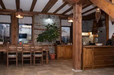 a restaurant with a table and chairs and a brick wall at Къщата на музиканта in Leshten