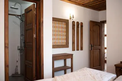 a bedroom with a bed and a shower and a door at Къщата на музиканта in Leshten