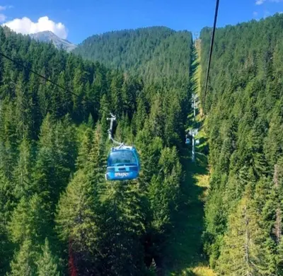 a blue car on a ski lift in a forest at Crystal Apartment Bansko in Bansko