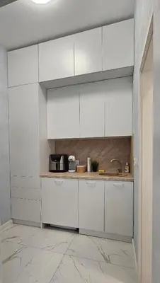 a kitchen with white cabinets and a counter at Urban Stay Sofia in Sofia