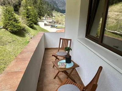 a balcony with two chairs and a table and a window at TRIIBRIA Guest house in Trigrad