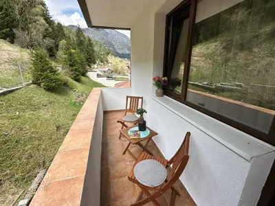 a balcony with two chairs and a table and a window at TRIIBRIA Guest house in Trigrad