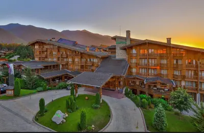 a large building with a resort in the mountains at Apartment 78 by the pool in Bansko