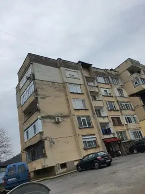 a tall building with cars parked in front of it at TONI'S Apartament in Bŭnzareto