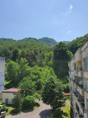 arial view of a building with trees and mountains in the background at TONI'S Apartament in Bŭnzareto