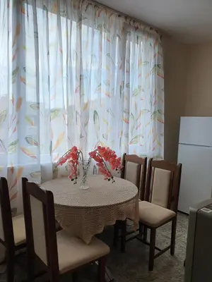 a dining room with a table and chairs and a refrigerator at TONI'S Apartament in Bŭnzareto