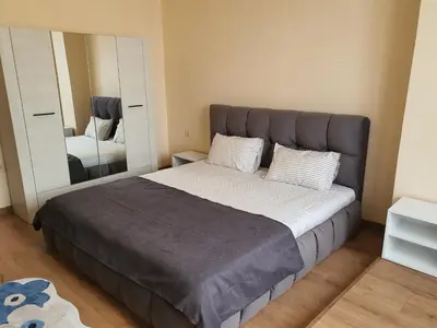 a bedroom with a large bed with a large mirror at TONI'S Apartament in Bŭnzareto