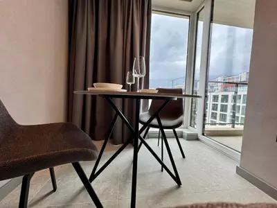 a table and chairs in a room with a window at Eleve Residences - Stone Studios in Sofia
