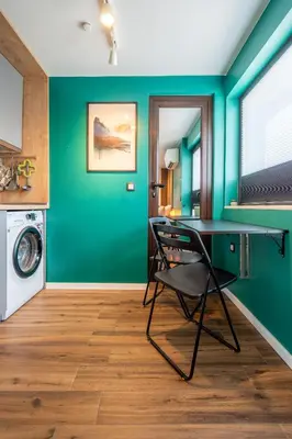 a laundry room with a chair and a green wall at Leafy Loft in Sofia