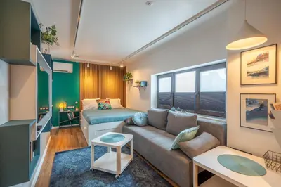 a living room with a couch and a bed at Leafy Loft in Sofia