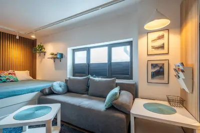 a living room with a couch and a bed at Leafy Loft in Sofia
