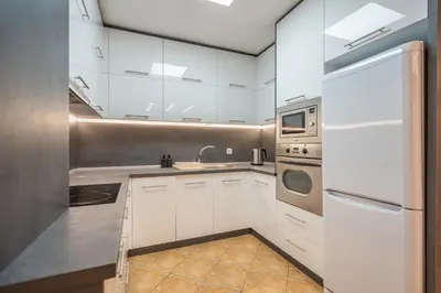 a kitchen with white cabinets and a white refrigerator at Marble place in Sofia