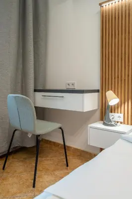 a bedroom with a desk and a chair next to a bed at Marble place in Sofia