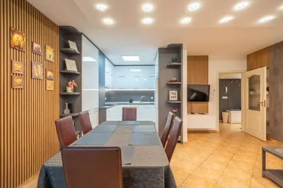a dining room with a table and a kitchen at Marble place in Sofia